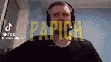a man wearing headphones is standing in front of a screen that says papich .