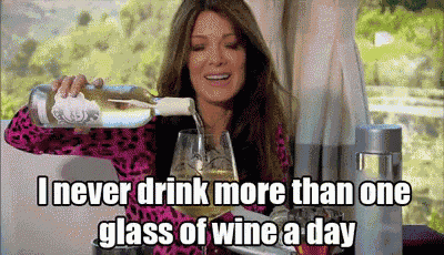 a woman is pouring wine into a glass .