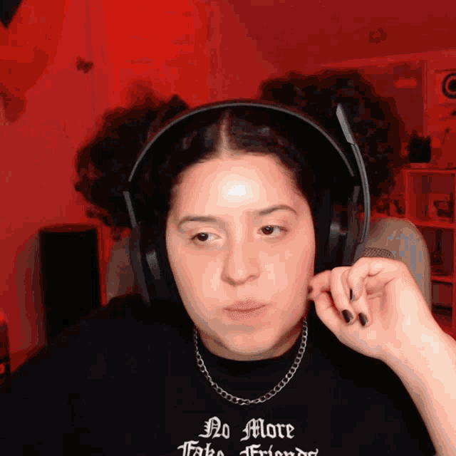 a woman wearing headphones and a t-shirt that says no more fake friends