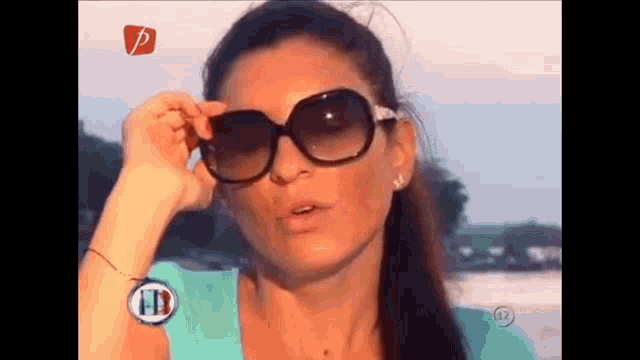 a woman wearing sunglasses and a watch with the letter p on it .