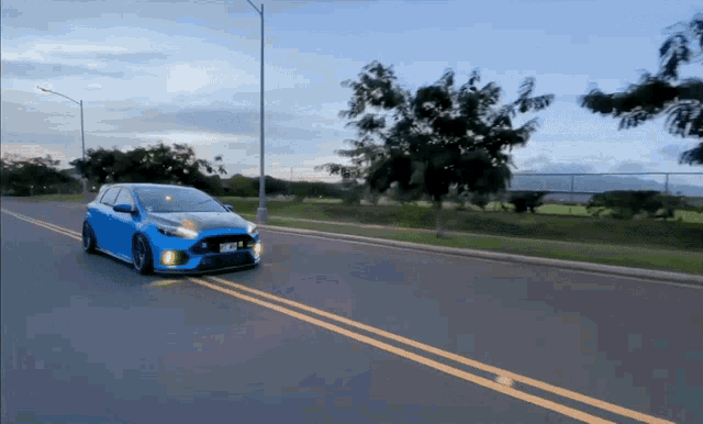 a blue car is driving down a road with a license plate that says ' jmc ' on it