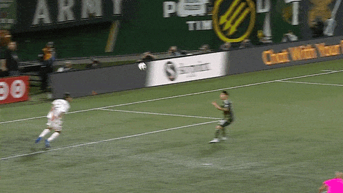 two soccer players on a field with an ad for skypoint in the background