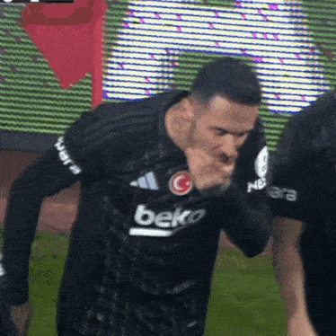 a soccer player wearing a beko jersey covering his mouth