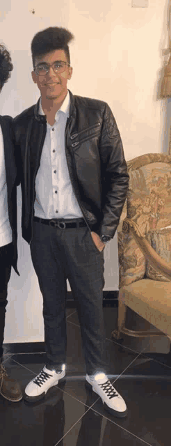 a young man wearing a black leather jacket and a white shirt