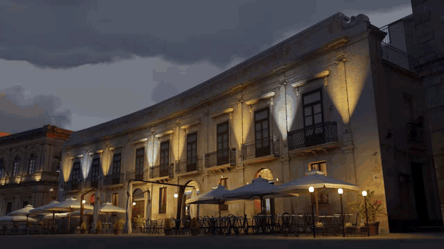 a building with a lot of windows and umbrellas