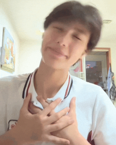 a man in a white shirt has his hands on his chest and his eyes are closed