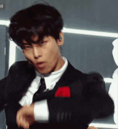 a young man in a suit and tie is dancing
