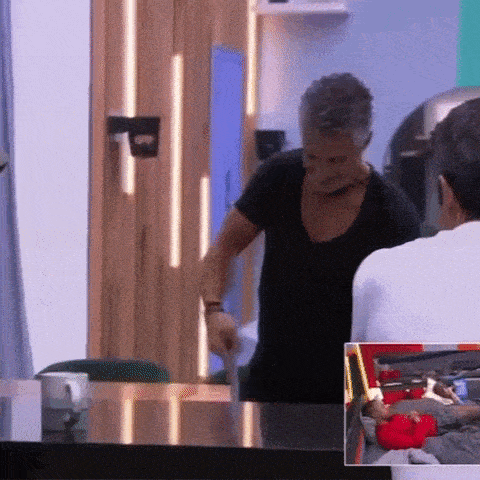a man in a black shirt is standing at a table talking to a man in a white shirt .