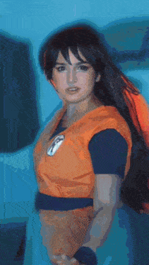 a woman in a dragon ball z costume is standing in front of a blue background