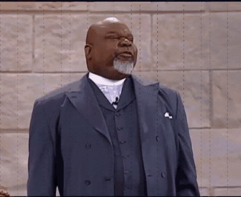 a man in a suit is standing in front of a wall