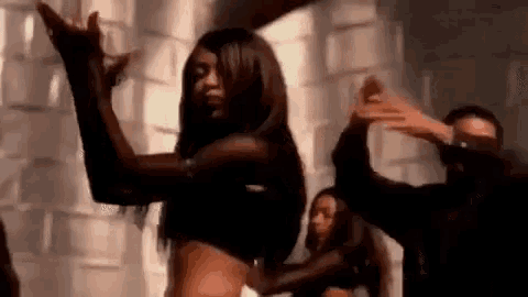 a woman is dancing in front of a group of people .