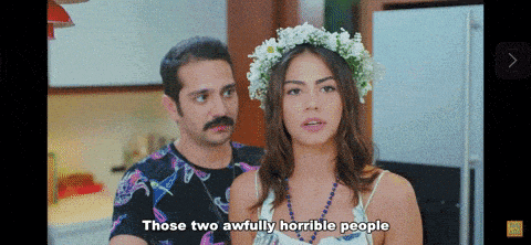a woman wearing a flower crown says " those two awfully horrible people " next to a man
