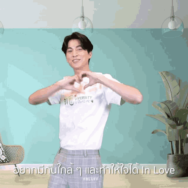 a man making a heart shape with his hands wearing a shirt that says bio university