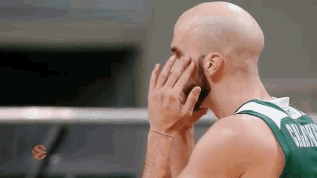 a bald man with a beard is wearing a green jersey with the name paulo written on it
