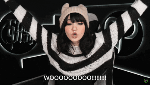 a woman wearing a black and white striped sweater and a hat says wooooooo