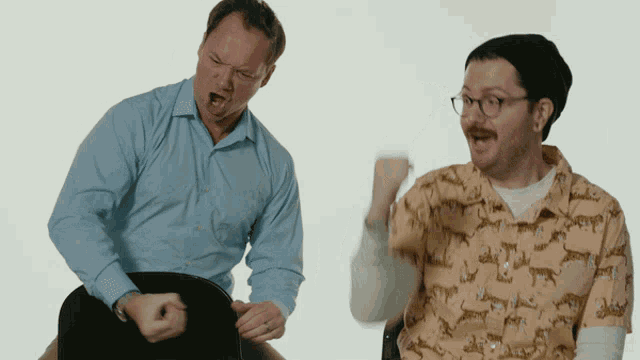 a man wearing a shirt with a leopard print is sitting next to another man