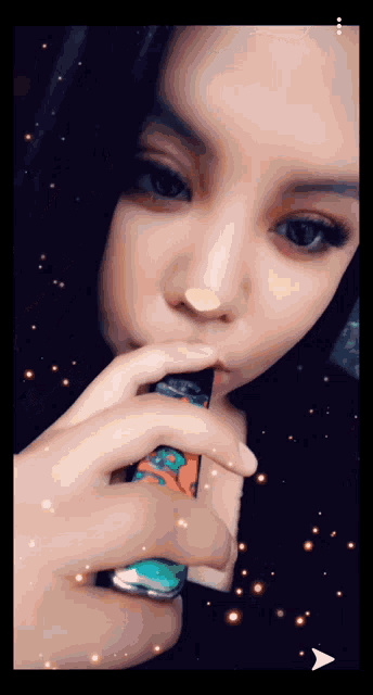 a woman is smoking an electronic cigarette with a blue and orange design