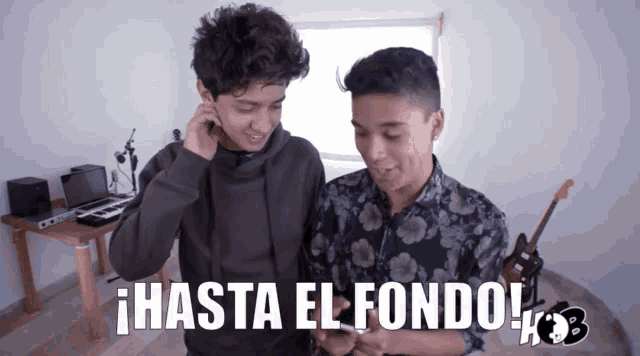 two boys looking at a cell phone with the words hasta el fondo written on the bottom