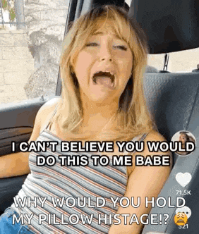 a woman is sitting in the back seat of a car and screaming .