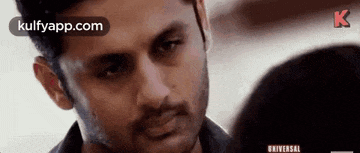 a man with a beard is looking at a woman 's face .