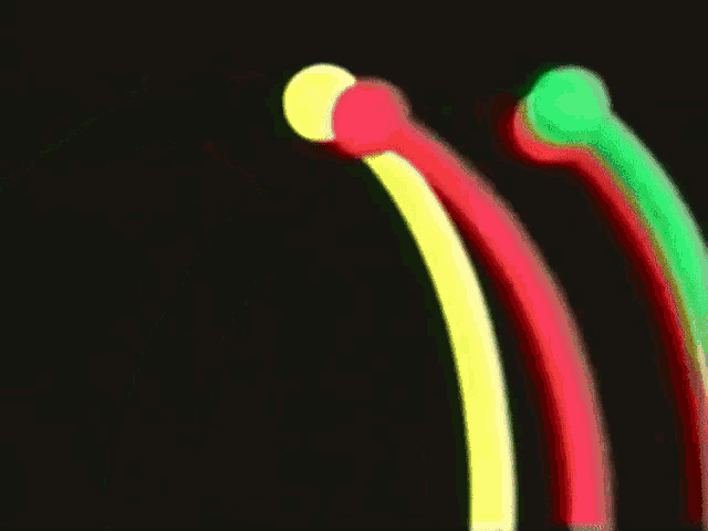 three glow in the dark sticks are lined up in a row on a black background .