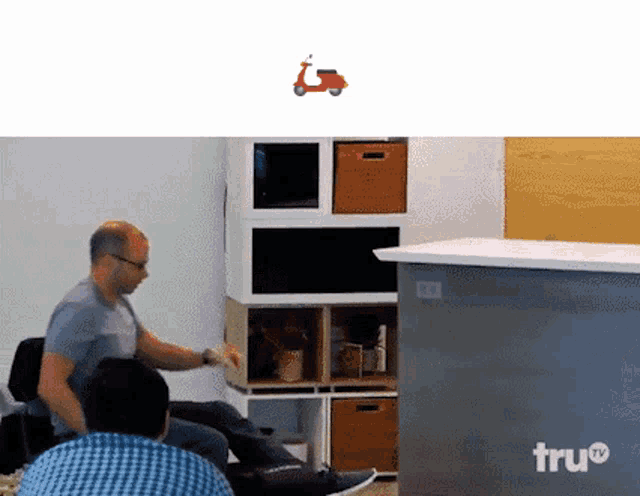 a man is sitting in a chair with a scooter in the background