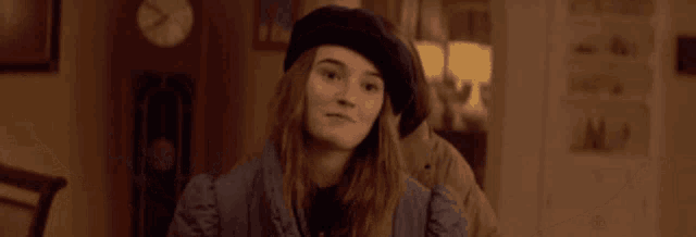 a girl with her arms outstretched is wearing a black beret