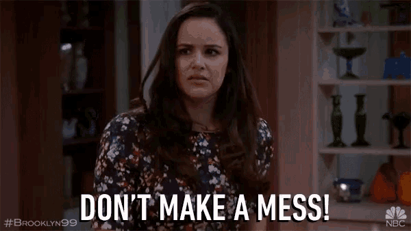 a woman says do n't make a mess in front of a shelf