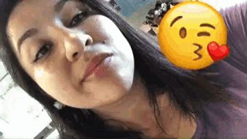 a woman is taking a selfie with a smiley face and a heart on it .