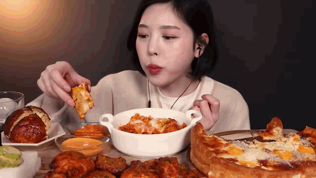 a woman is eating a lot of food at a table .