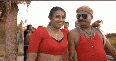 a man and a woman are posing for a picture and the man is wearing sunglasses