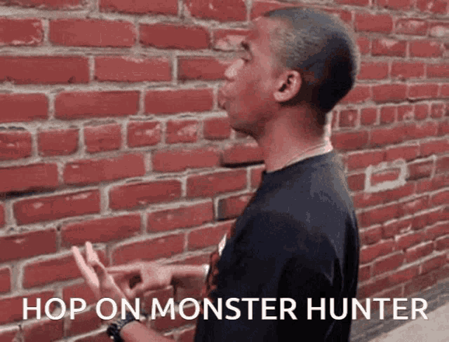 a man standing in front of a brick wall with the words hop on monster hunter