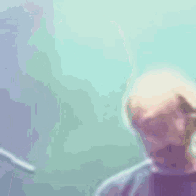 a blurry picture of a man wearing a purple shirt and a brown strap .