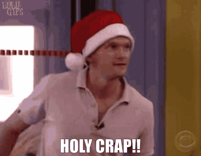 a man wearing a santa hat says holy crap !