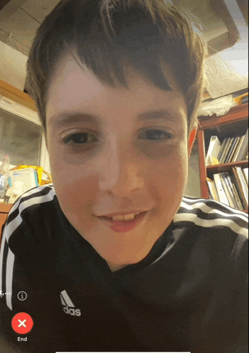 a boy wearing a black adidas shirt has a red x on the end button