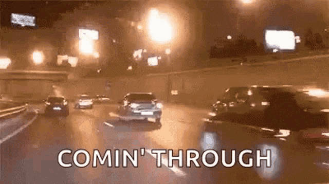 a group of cars are driving down a highway at night and the words comin ' through are visible .
