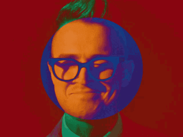 a man wearing glasses is smiling in a blue circle