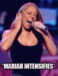 a woman singing into a microphone with the words " mariah intensifies " above her