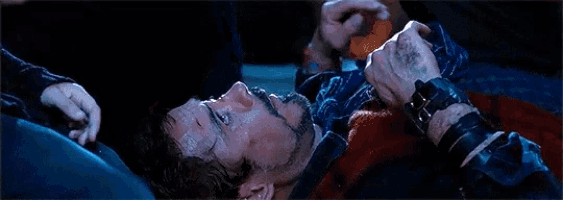 a young boy is crying in a dark room while looking at another person .