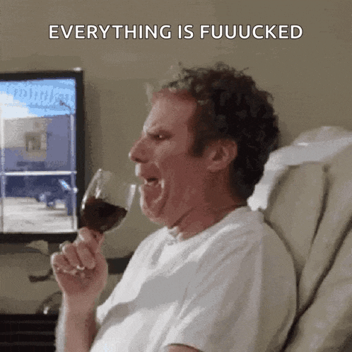 a man is sitting in a chair drinking a glass of wine and making a face .
