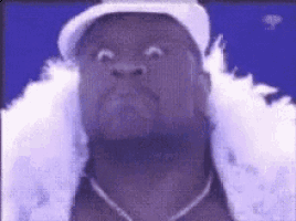 a man wearing a hat and feather boa is making a face .