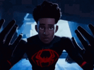 a man is standing in a dark room with his hands outstretched .
