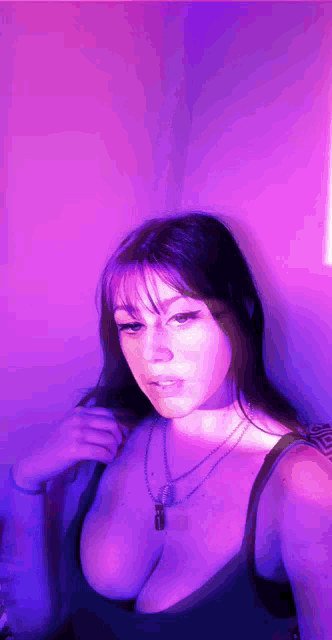 a woman with large breasts is standing in front of a purple background
