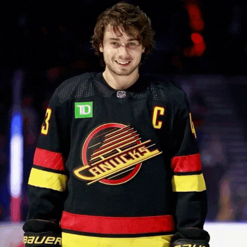 a man in a canucks jersey with the letter c on it