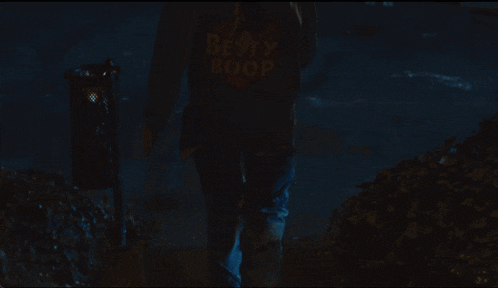 a man in a denim jacket has a patch on his back that says ' happy ' on it