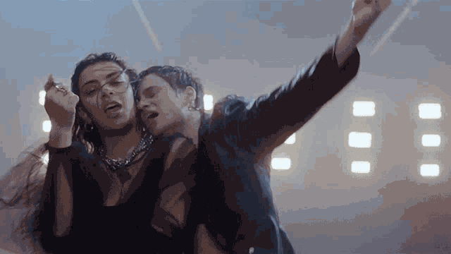 a man and a woman are dancing in a dark room