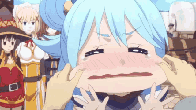 a girl with blue hair is crying while being held by someone 's hands