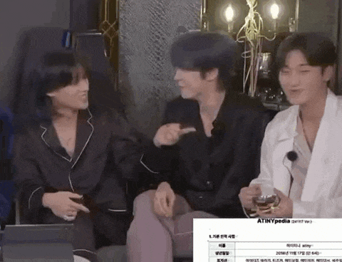 a group of young men are sitting next to each other on a couch and laughing .