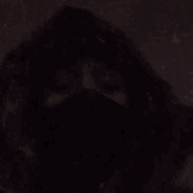 a close up of a person 's face in a dark room