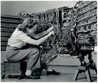a black and white photo of two women working on wires